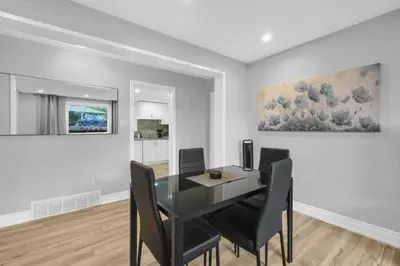a dining room with a glass table and black chairs at Stylish 3 BR Apt with Free Parking, Wifi and Patio in Whitby