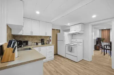 a kitchen with white cabinets and white appliances at Stylish 3 BR Apt with Free Parking, Wifi and Patio in Whitby