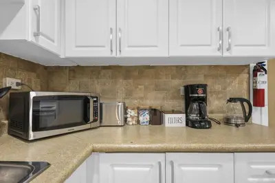 a kitchen counter with a microwave and a coffee maker at Stylish 3 BR Apt with Free Parking, Wifi and Patio in Whitby