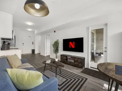 a living room with a blue couch and a tv at Stylish 1BR Condo in Prime Location with Parking and Wi Fi in Kitchener