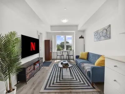a living room with a blue couch and a tv at Stylish 1BR Condo in Prime Location with Parking and Wi Fi in Kitchener