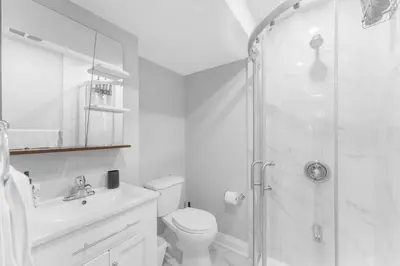 a bathroom with a shower and a toilet and a sink at Modern 2-Bed, 2-Bath BSMT suite with Pvt Entrance Free Parking and Wi Fi in Pickering