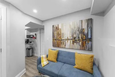 a living room with a blue couch with yellow pillows at Modern 2-Bed, 2-Bath BSMT suite with Pvt Entrance Free Parking and Wi Fi in Pickering