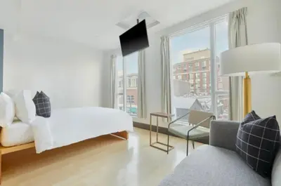 a bedroom with a white bed and a large window at The Beverley Hotel in Toronto
