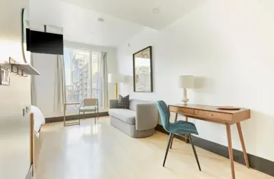 a living room with a desk and a couch at The Beverley Hotel in Toronto