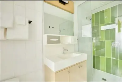 a white bathroom with a sink and a shower at The Beverley Hotel in Toronto