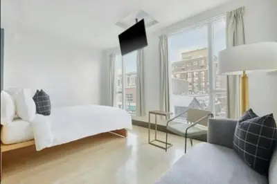 a living room with a white couch and a window at The Beverley Hotel in Toronto