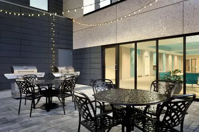 a patio with tables and chairs and a grill at Home2 Suites by Hilton Milton Ontario in Milton