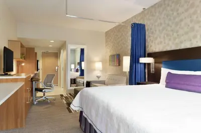 a hotel room with a large bed and a desk at Home2 Suites by Hilton Milton Ontario in Milton
