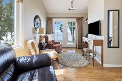 a living room with a leather couch and a desk at Serene Waterfront Escape On Private Lane in Thornbury