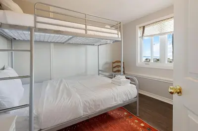 a bedroom with two bunk beds and a window at Serene Waterfront Escape On Private Lane in Thornbury