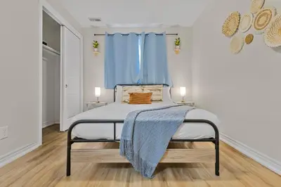 a bedroom with a bed with a blue curtain at Niagara Retreat|HotTub|Sauna|Games|15 Min to Falls in Thorold