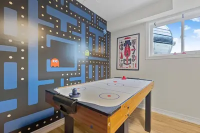 a ping pong table in a room with a wall at Niagara Retreat|HotTub|Sauna|Games|15 Min to Falls in Thorold