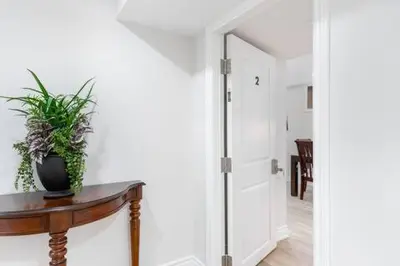 a hallway with a table with a potted plant on it at Cozy 3BR 2 Bath Lower Level Close to Shops in Richmond Hill