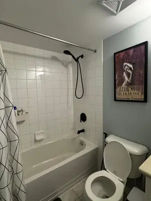 a bathroom with a tub and a toilet and a poster at DT Townhome 1BR steps to transit in Toronto
