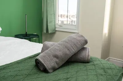 a rolled up towel sitting on top of a bed at Joyful Haven|KingBed|Air Hockey| 10 mins to Falls in Thorold