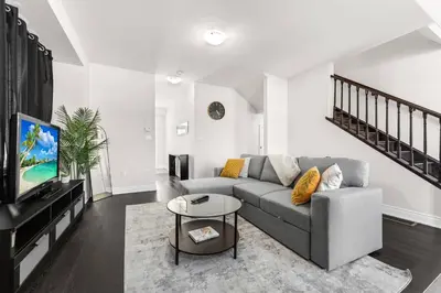 a living room with a couch and a tv at Joyful Haven|KingBed|Air Hockey| 10 mins to Falls in Thorold