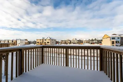 a balcony with a snow covered bench on a deck at Joyful Haven|KingBed|Air Hockey| 10 mins to Falls in Thorold