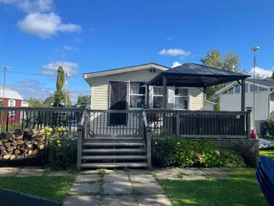 a house with a porch and an umbrella at Lakefront Lake Erie with Amazing Views 3BR Pet Friendly 1 HR from Hamilton and Niagara