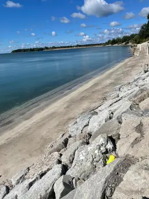 a beach with some rocks and the water at Lakefront Lake Erie with Amazing Views 3BR Pet Friendly 1 HR from Hamilton and Niagara