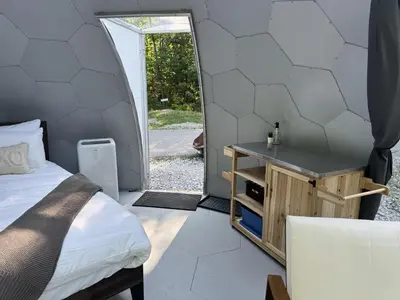 a bedroom with a bed and an open door at Rare Mirrored Glamping Dome in Severn