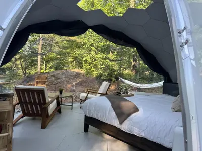a bedroom with a bed and a balcony with a view at Rare Mirrored Glamping Dome in Severn