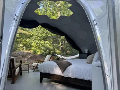 a bedroom with a bed and a large window at Rare Mirrored Glamping Dome in Severn