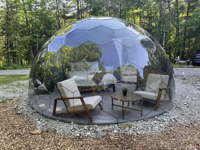 a sphere with chairs and a table in it at Rare Mirrored Glamping Dome in Severn
