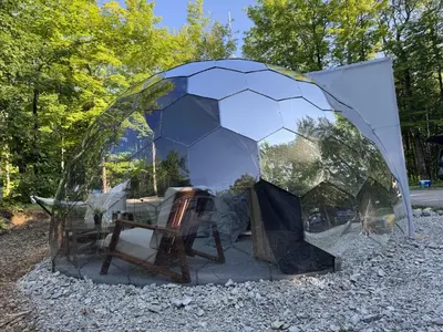 a soccer ball tent with a chair in it at Rare Mirrored Glamping Dome in Severn