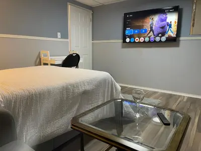 a room with a bed and a tv on the wall at Renaissance Guest House in Oshawa