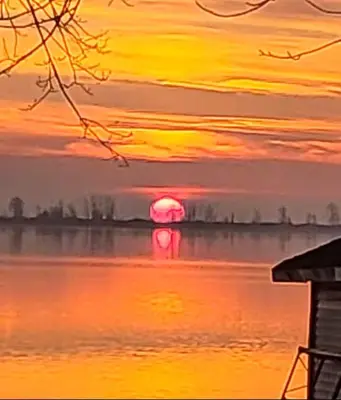 a sunset over a body of water with the sun setting at Waterfront Comfy Guesthouse, PEC in Carrying Place