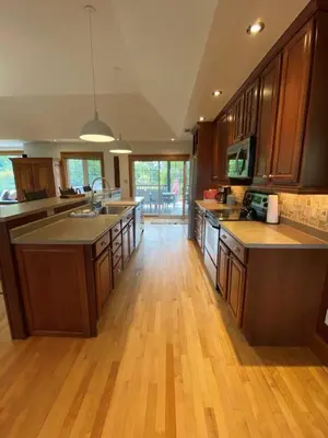 a large kitchen with wooden floors and wooden cabinets at Private Beach Hot Tub A Vacay to Remember in Hillier