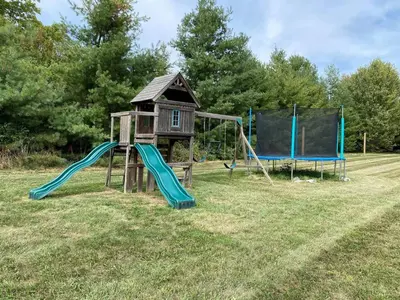 a playground with a house and a slide at Private Beach Hot Tub A Vacay to Remember in Hillier