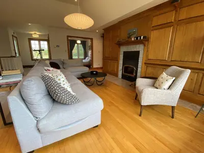 a living room with a couch and chairs and a fireplace at Private Beach Hot Tub A Vacay to Remember in Hillier