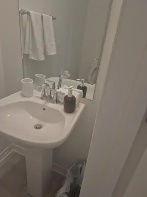 a white bathroom with a sink and a mirror at Stylish 3BR 2.5 Bath Townhouse with Patio and parking in Mississauga