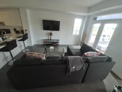 a living room with a couch and a table at Stylish 3BR 2.5 Bath Townhouse with Patio and parking in Mississauga