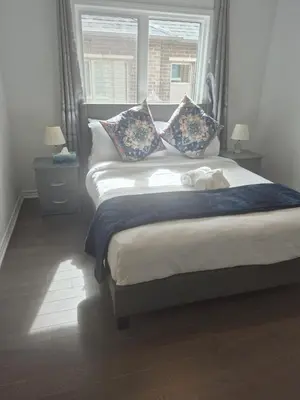 a bedroom with a large bed with a window at Stylish 3BR 2.5 Bath Townhouse with Patio and parking in Mississauga