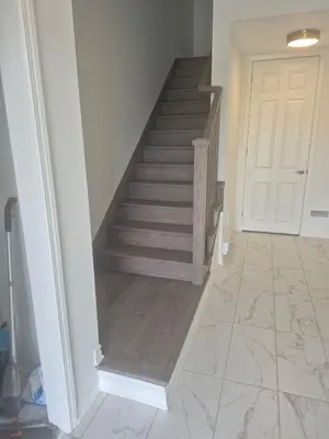 a hallway with a staircase and a white door at Stylish 3BR 2.5 Bath Townhouse with Patio and parking in Mississauga