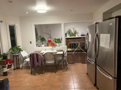 a kitchen with a table and a stainless steel refrigerator at Private comfortable M1 bedroom in Mississauga