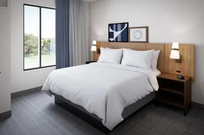 a hotel room with a large bed and a window at Staybridge Suites Aurora East by IHG in Aurora