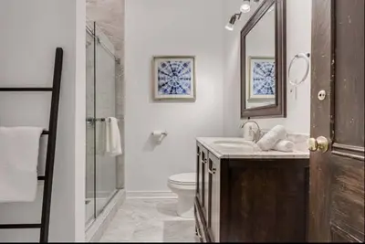 a bathroom with a toilet and a sink and a mirror at Modern Industrial Suite w Private Patio - The Roland in Toronto