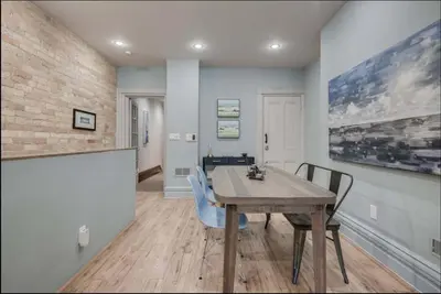 a dining room with a wooden table and chairs at Modern Industrial Suite w Private Patio - The Roland in Toronto