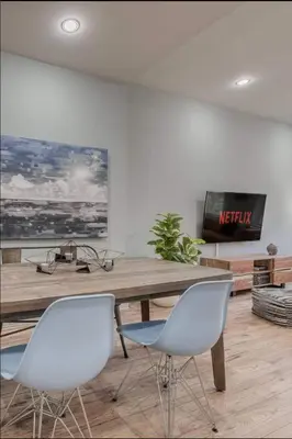 a living room with a wooden table and two chairs at Modern Industrial Suite w Private Patio - The Roland in Toronto