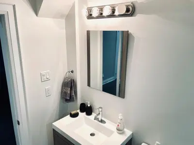 a white bathroom with a sink and a mirror at Heaven on Earth in Ajax
