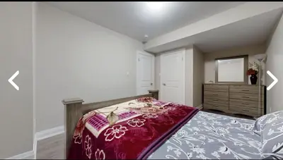 a bedroom with a bed and a dresser with a mirror at Heaven on Earth in Ajax