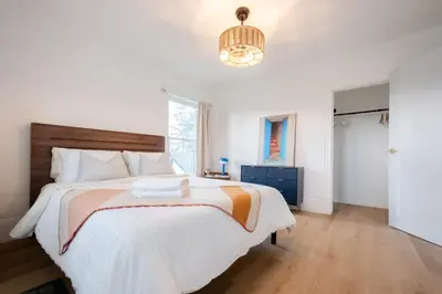 a bedroom with a large bed and a window at County Cove - Newly Renovated Century Home in Carrying Place