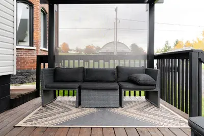 a porch with a couch on a deck at County Cove - Newly Renovated Century Home in Carrying Place