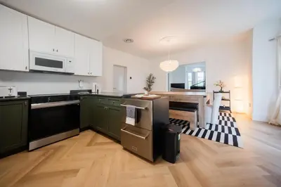 a kitchen with green cabinets and a dining room at County Cove - Newly Renovated Century Home in Carrying Place