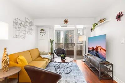 a living room with a couch and a tv at Luxe 3BR 2 Bath Condo Steps from Square one Mall in Mississauga