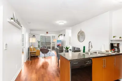 an open kitchen and living room with a counter top at Luxe 3BR 2 Bath Condo Steps from Square one Mall in Mississauga